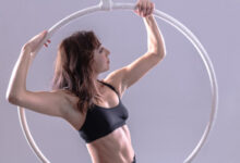 Aerial Hoop Weiß mit einer Frau. Das Bild wird für den Blog eintrag "Aerial Hoop Übersicht" genutzt.